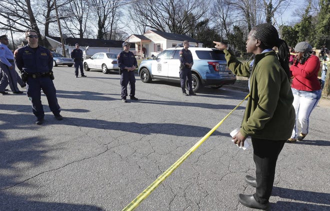 A woman yells at police near the scene of a fatal shooting in Raleigh on Monday. Authorities said that a police officer shot and killed a man while trying to make an arrest for a felony drug charge. (AP Photo/Gerry Broome)