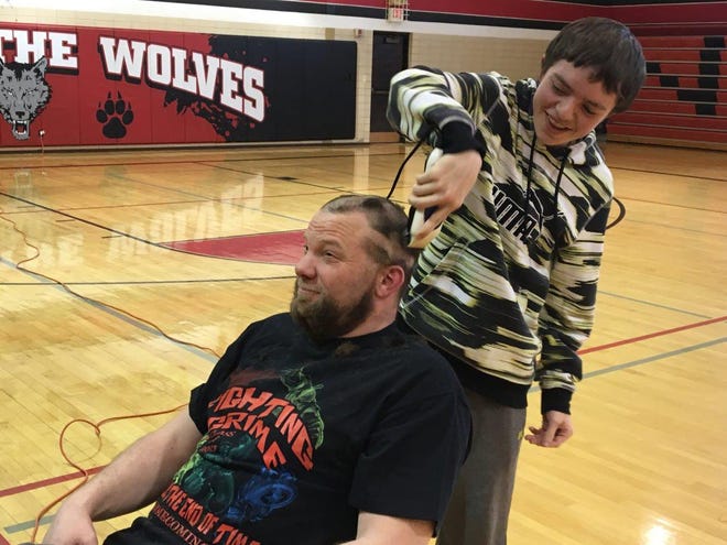 Pearl City Junior/Senior High School history teacher Josh Robbins gets his head and beard shaved after children’s books are collected to be sent to Amy Beverland Elementary School in Indiana. PHOTO PROVIDED