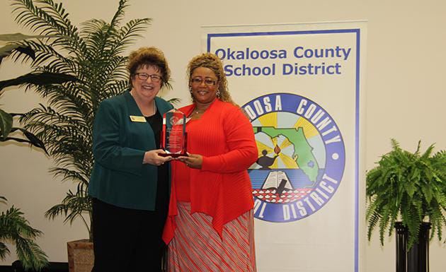 Okaloosa School Superintendent Mary Beth Jackson (left) awards Juanita Payne-Galbreath, an ESE paraprofessional at Crestview High School, the Okaloosa County Education Support Professional of the Year.