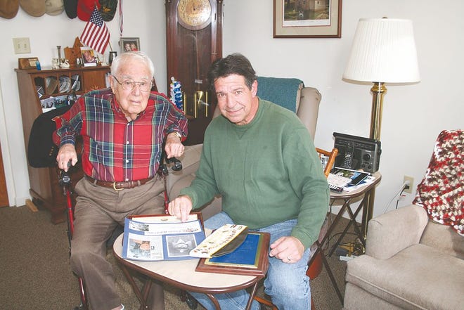 Max Izer and Rick Hess, members of Greencastle VFW Post 6319, look at 70 years’ worth of scrapbooks and honors belonging to Izer. At 96, Izer is the final living charter member of the club.