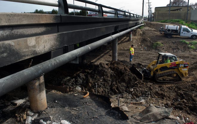 A crew works on repairs Wednesday of the bridge on South Wilson Way between East Hazelton Avenue and East Martin Luther King Jr. Boulevard over Mormon Slough after it was damaged by a fire. CLIFFORD OTO/THE RECORD