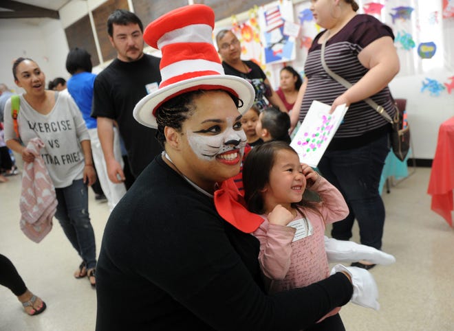 LeeAnn Wilson, playing the Cat in the Hat, hugs Evelyn Vang, 3, during Creative Child Care's celebration of Dr. Seuss' birthday held Wednesday at St. Paul United Methodist Church. CALIXTRO ROMIAS/THE RECORD