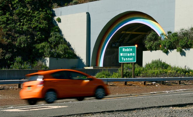 In this photo from Tuesday, March 1, 2016, a sign stands at the northbound entrance to the recently renamed Robin Williams Tunnel in Sausalito, Calif. A tunnel with rainbow arches that connects the Golden Gate Bridge to greater Marin County has officially become the Robin Williams tunnel. The tunnel was unofficially known as the Waldo Tunnel. The California State Senate last year approved a resolution to change the tunnel's name to honor the late actor and comedian. Williams grew up and lived in the Bay Area. (Alan Dep/Marin Independent Journal via AP)