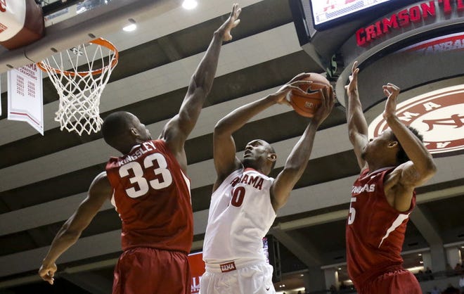 Alabama's Jimmie Taylor is bracketed by Arkansas' Moses Kingsley and Anthlon Bell as he attempts to shoot in the lane in Coleman Coliseum during Bama's final home game of the season Wednesday, March 2, 2016. Staff Photo/Gary Cosby Jr.