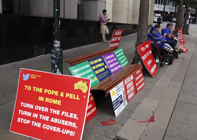 A small protest group gather with placards outside an inquiry into child sex abuse in Sydney, Tuesday, March 1, 2016. Cardinal George Pell, One of Pope Francis' top advisers told an Australian inquiry into child sex abuse, via video link from Italy, that an Australian bishop had deceived him about the reason a pedophile priest was repeatedly transferred from parish to parish. (AP Photo/Rick Rycroft)