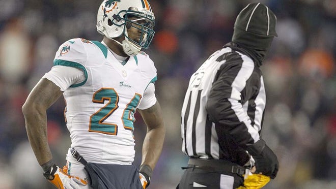 Miami Dolphins cornerback Sean Smith (24) looks at side judge Joe Larrew (73) after getting called for a holding penalty at Gillette Stadium in Foxboro, Mass on December 30, 2012. (Allen Eyestone/The Palm Beach Post)