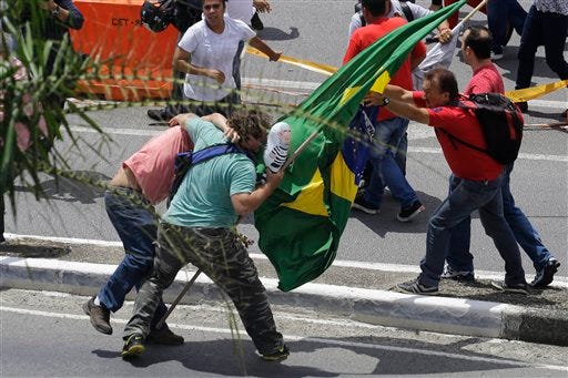 Supporters of former President Luiz Inacio Lula da Silva clash with anti-government demonstrators in front of the Congonhas airport federal police station in Sao Paulo, Brazil, Friday, March 4, 2016. Brazilian police acting on a warrant questioned former President Luiz Inacio Lula da Silva and searched his home and other properties, in the most recent development yet in the sprawling corruption case at the oil giant Petrobras.