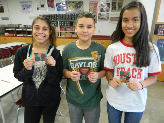 Mackenzie Aguirre, Ceasar Rodriguez, and Angela Romero show the cards they chose from Early Middle School.