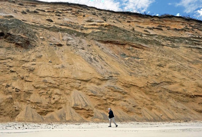 The photographer's wife, Patti, walks alongside the beachside cliffs of the Outer Cape. PHOTO COURTESY OF MARK MCGRATH