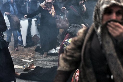 Women run as riot police use tear gas and water cannons to disperse people gathered in support outside the headquarters of Zaman newpaper in Istanbul, Saturday, March 5, 2016. Police have erected fences and are standing watch in front of the headquarters of Turkey's largest-circulation newspaper a day after it used tear gas and water cannons to storm the building and enforce a court-ordered seizure. The seizure of Zaman newspaper and its sister outlets Friday has escalated fears over media freedom in Turkey.