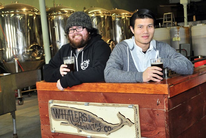 Assistant brewer Christopher Smith, left, and co-owner Andy Tran of Whaler’s Brewing Co. enjoy a relaxed moment during the brewery’s recent renovation. In the background are some of the newly acquired fermentation vessels that will give Whaler’s six times its previous production capacity. Pictured above are some taps.