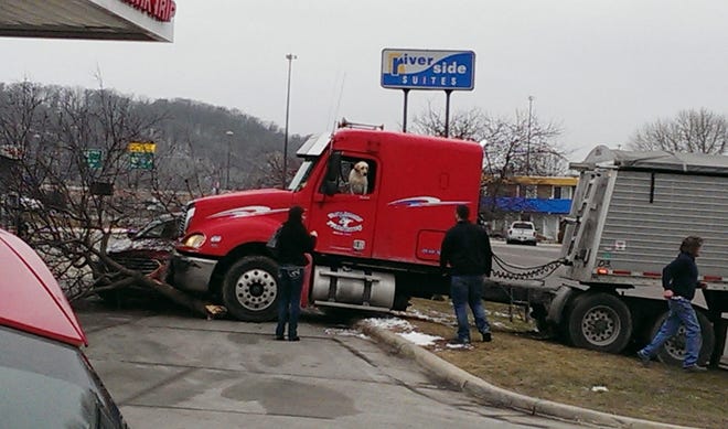 This Friday, March 4, 2016 photo provided by David Stegora shows a semi-truck with a dog in the driver's seat that crashed at a convenience store in Mankato, Minn. Customers at a Minnesota gas station saw a golden Labrador retriever appear to drive the semi across a road Friday. Mankato police said the idling truck apparently was put into gear, then went through a parking lot, across the street and over a curb. (David Stegora via AP)