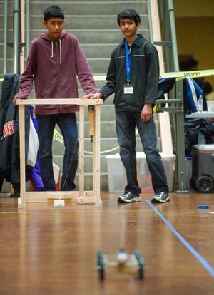 Wicklund School students Jonah Linsangan, left, and Prakrit Goel watch as their device sends a small cart with an egg attached to the front down a course in the scarmbler competition at the 30th annual San Joaquin County Regional Science Olympiad on Saturday at McNair High School. In the scrambler event, students built a device to send the cart down a straight path and make it stop closest to a wall without crashing into it and breaking the egg. CLIFFORD OTO/THE RECORD