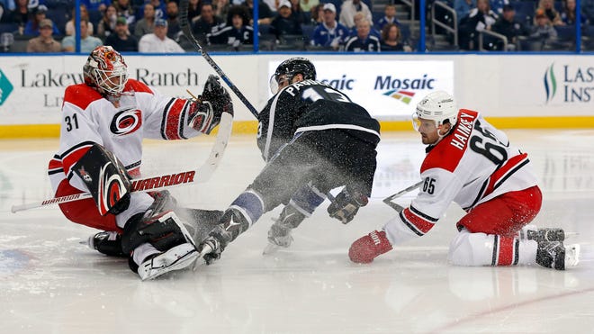 Carolina Hurricanes goalie Eddie Lack (31), of Sweden, makes a save on Tampa Bay Lightning's Cedric Paquette, as Hurricanes' Ron Hainsey defends during the second period of an NHL hockey game Saturday, March 5, 2016, in Tampa, Fla.