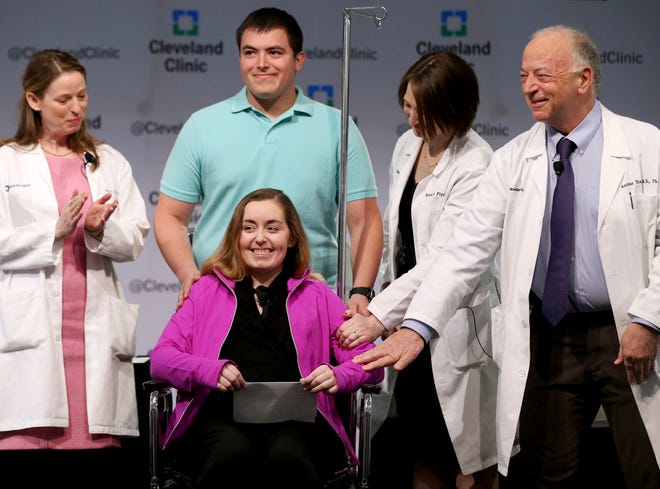 Lindsey and her husband Blake stand with Cleveland Clinic medical staff as they announce she was the nation's first uterus transplant patient, Monday, March 7, 2016, in Cleveland. Standing with the couple, from left, are Ruth M. Farrell, M.D., bio-ethicist, Rebecca Flyckt, M.D., OB/GYN surgeon, and Andreas Tzakis, M.D., program director of the Transplant Center. Lindsey, who didn't want to use her last name to protect the privacy of her family, said that she prayed for years to be able to bear a child, and is grateful to the deceased donor's family and surgeons who've given her that chance. (Marvin Fong/The Plain Dealer via AP)