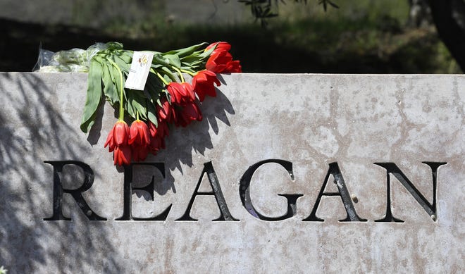 Flowers sit atop the sign Sunday at the entrance to the Ronald Reagan Presidential Library in Simi Valley, Calif. Former first lady Nancy Reagan died Sunday at 94. Associated Press/Mark J. Terrill