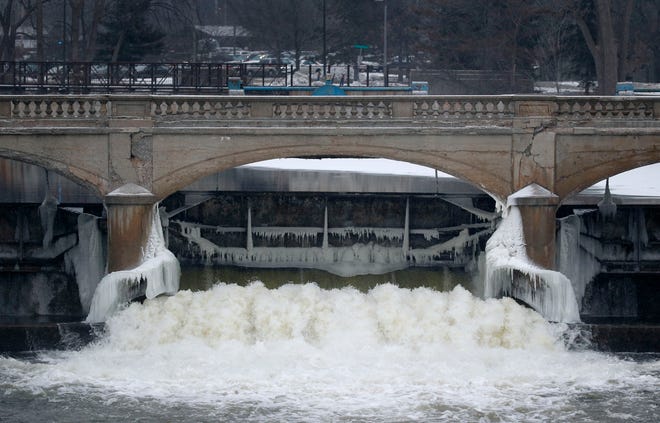 In this Jan. 21 file photo, water from the Flint River flows through the Hamilton Dam near downtown Flint, Mich. A lawsuit stemming from Flint's lead-contaminated water was filed Monday on behalf of the city's residents against Michigan Gov. Rick Snyder as well as other current and former government officials and corporations.