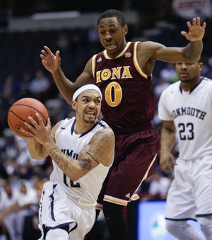 Monmouth guard and Kingston graduate Justin Robinson (12) drives past Iona guard Rickey McGill (0) during the first half of the championship game of the MAAC tournament. The Associated Press