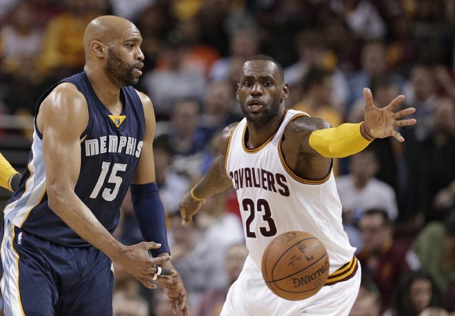 Vince Carter of the Grizzlies passes around the Cavaliers' LeBron James.