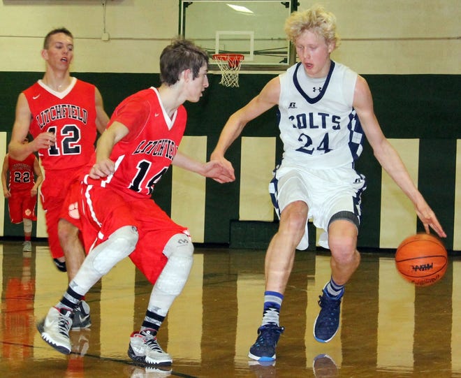 Six-foot-six Peter Kalthoff shows off his ball-handling skills during Monday night's District opener against Litchfield. Defending is the Terriers Jacob Rose. MIKE LINVILLE PHOTO