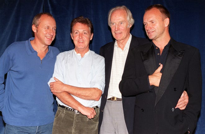 FILE - In this Sept. 15 1997 file photo, producer George Martin, second right poses for photographers with musicians Mark Knopfler, Paul McCartney and Sting, prior to the start of the Music for Montserrat benefit concert, in London. George Martin, the Beatles' urbane producer who guided, assisted and stood aside through the band's swift, historic transformation from rowdy club act to musical and cultural revolutionaries, has died, his management said Wednesday, March 9, 2016. He was 90. (Rebecca Naden/PA via AP, File)