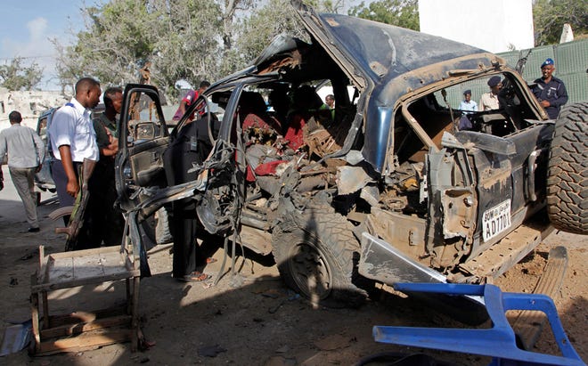 The wreckage of a car used for a suicide bombing sits outside a police academy in Mogadishu, Somalia, Wednesday, March 9, 2016. A Somali police official said three police officers and one civilian have been killed in a car bombing. Gen. Ali Hersi Barre said that a suicide car bomber detonated an explosives-laden vehicle outside a cafe near the academy. (AP Photo/Farah Abdi Wasameh)