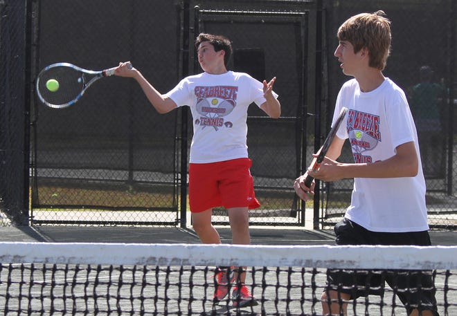 Seabreeze's Collin West returns a shot with doubles partner James Vuille-Kowing looking on Wednesday in Daytona Beach. NEWS-JOURNAL/DAVID TUCKER