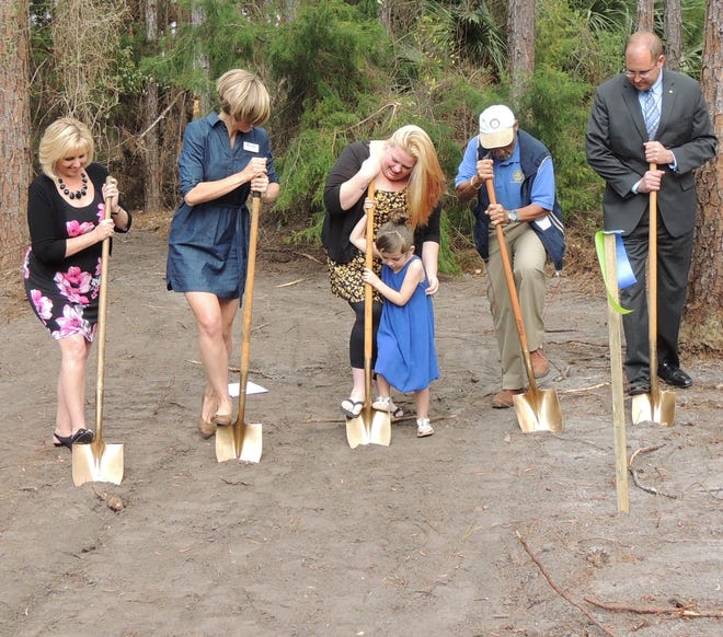 From left, Flagler Habitat for Humanity president Sandra McDermott, Flagler Habitat for Humanity executive director Lindsay Elliot, future Habitat for Humanity homeowners Christina Whitaker and daughter Kaydence Bliss, Rotary Club of Flagler County member Jim Callendar, Rotary Club of Flagler County Matt Maxwell dig in at the groundbraking ceremony for Whitaker's home. NEWS-TRIBUNE/DANIELLE ANDERSON