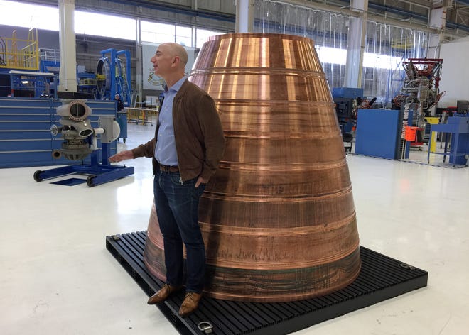 Amazon.com founder Jeff Bezos stands next to a copper exhaust nozzle to be used on a space ship engine during a media tour of Blue Origin, the space venture he founded, Tuesday, March 8, 2016, in Kent, Wash. The private space company opened its doors to the media for the first time on Tuesday to give a glimpse of how organizations like Blue Origin are creating the next generation of rockets for private and public use. (AP Photo/Donna Blankinship)