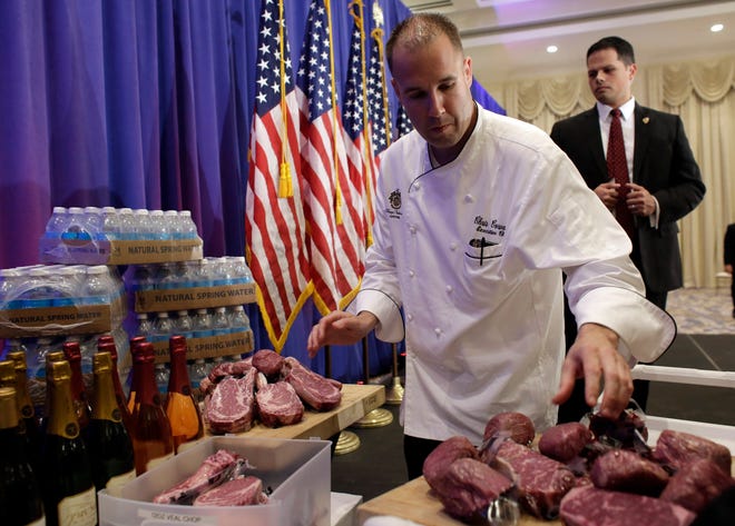 A chef with the Trump National Golf Club arranges Trump steaks for a display before a news conference Tuesday by Republican presidential candidate Donald Trump. Trump-branded steaks, wine, and water were on display next to the stage. 

Lynne Sladky/The Associated Press