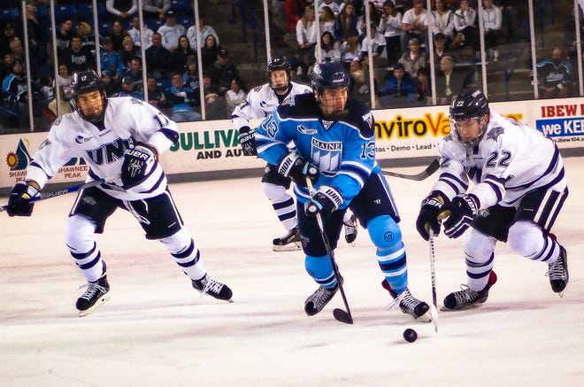 UNH's Ara Nazarian, right, challenges a Maine player for the puck during Hockey East action earlier this year. UNH had one of its worst seasons in almost 30 years. Shawn St. Hilaire/Fosters.com