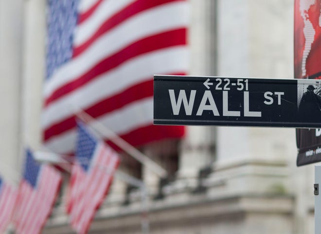 In this Aug. 8. 2011, file photo, a Wall Street sign hangs near the New York Stock Exchange, in New York. Global shares rose Friday, with Europe off to a strong start as investors reassessed an unexpectedly wide array of stimulus measures announced a day earlier by the European Central Bank.