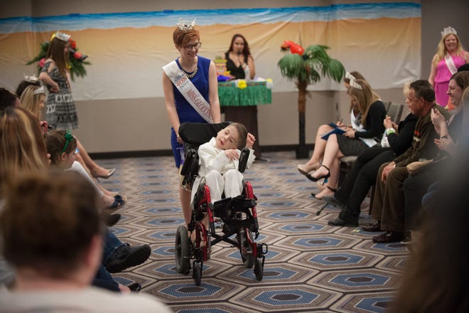 Miss Gloucester County's Teen Shelby Watts, 16, of Vineland, escorts Ronnie Seal, 6, of Levittown, down the runway during the evening wear portion of the Tiara's Loving Children Special Needs Pageant on Saturday, March 12, 2016, at the Sheraton Bucks County in Falls.