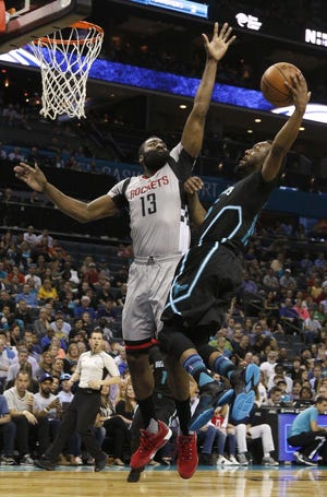 Houston's James Harden, left, tries to alter Charlotte's Kemba Walker's shot during their game in Charlotte on Saturday. (AP Photo/Bob Leverone)