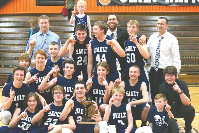Sault High celebrates with a Class B district championship trophy after defeating Grayling Friday night.