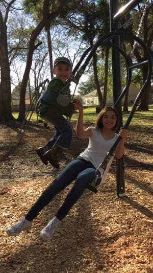 Levi Boyer, left, and Alyannah D'Aguiar play on an expression swing recently installed at Rotary Park in Edgewater.