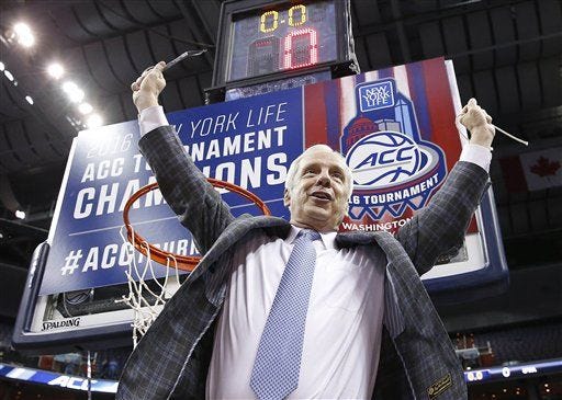North Carolina head coach Roy Williams holds part of the net after his team's win against Virginia in the ACC final.