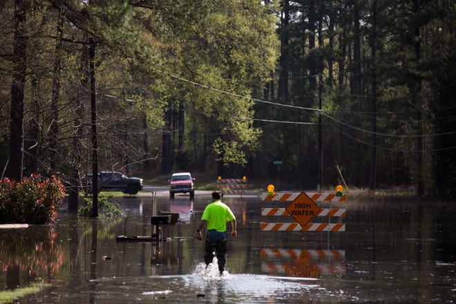 A man walks through floodwaters from Caddo Lake in Mooringsport, La., Sunday, March 13, 2016. President Barack Obama has signed an order declaring Louisiana's widespread flooding from heavy rains a major disaster.