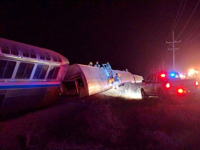 Emergency personnel work on a train that derailed near Dodge City, Kan., Monday, March 14, 2016. An Amtrak statement says the train was traveling from Los Angeles to Chicago early Monday when it derailed just after midnight. (Daniel Szczerba via AP) MANDATORY CREDIT