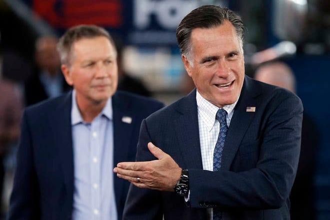 Republican presidential candidate, Ohio Gov. John Kasich, left, accompanied by former Republican presidential candidate Mitt Romney arrive for a campaign stop on Monday, March 14, 2016, at the MAPS Air Museum in North Canton, Ohio. (AP Photo/Matt Rourke)