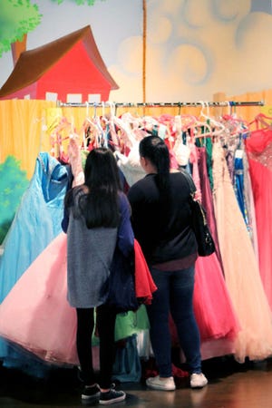 Jamie Mitchell • Times Record Yasmine, 14, looks at formal dresses with her mother, Misty Bolanos, Saturday, March 12, 2016, during the Once Upon A Prom at the Heritage United Methodist Church in Van Buren. 
 Jamie Mitchell • Times Record Sydne Tursky, left and Alex Gladden stock formal dresses for the 5th annual Once Upon A Prom, Saturday, March 12, 2016, at Heritage United Methodist Church in Van Buren.
