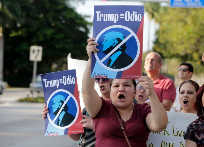 Berta Sandes, 38, of Miami, an undocumented immigrant from Nicaragua, holds a sign which translates to "Trump Equals Hate" during a protest against Republican presidential candidate Donald Trump outside of the Trump National Doral golf resort, Monday, March 14, 2016, in Doral, Fla. Voters go to the polls in Florida Tuesday for the primary election. (AP Photo/Lynne Sladky)