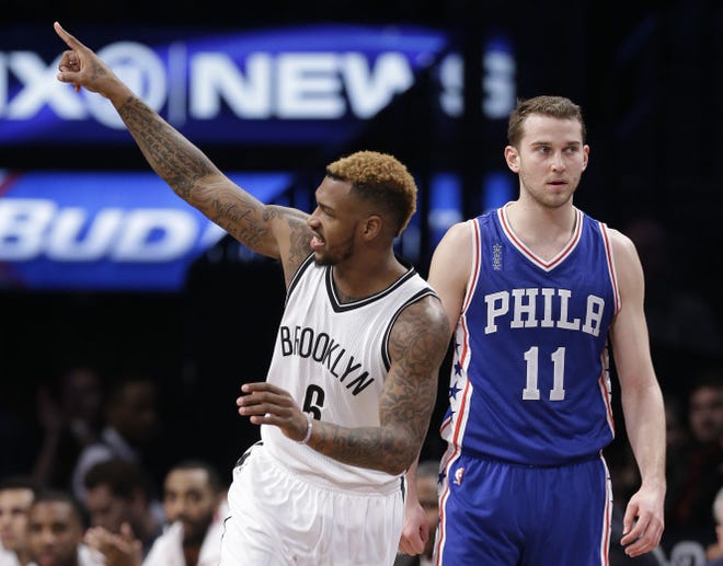 Nets guard Sean Kilpatrick (6) points to a teammate after hitting a 3-pointer in the fourth quarter of Tuesday's 131-114 Brooklyn victory at Barclays Center.  The Sixers' Nik Stauskas is at right.
