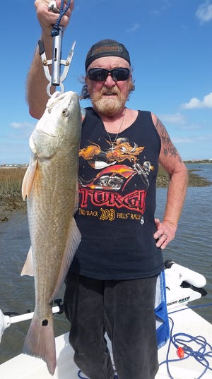 Stan Daniels, down for Bike Week from Pennsylvania, holds up one of many redfish he caught fishing in Flagler County waters last week.