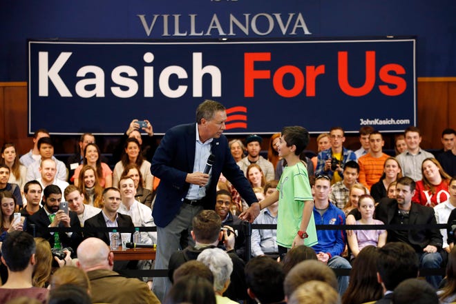 Republican presidential candidate Ohio Gov. John Kasich, left, meets with Jack Shapiro, 11, while speaking at a town hall event at Villanova University on Wednesday in Villanova, Pa. MATT SLOCUM/THE ASSOCIATED PRESS