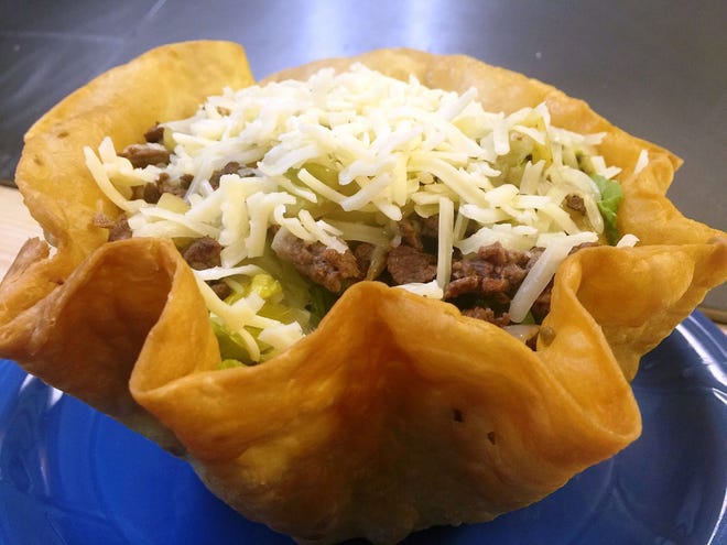 Taco salad at Mikasa Mexican Restaurant is served in a crunchy taco shell with rice, beans, salad, cheese and a choice of meat.