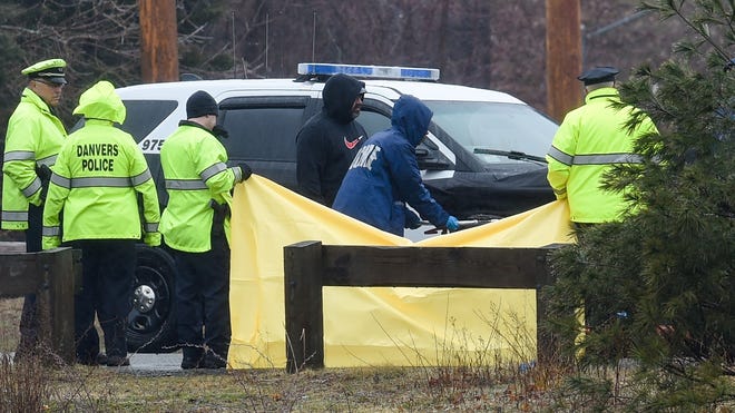 Danvers Police officers hold up a sheet as the Massachusetts Medical Examiner removes what appears to be a body that was recovered from the Mill Pond off Pond Street in Danvers on Tuesday, March 15. Wicked Local Staff Photo / David Sokol