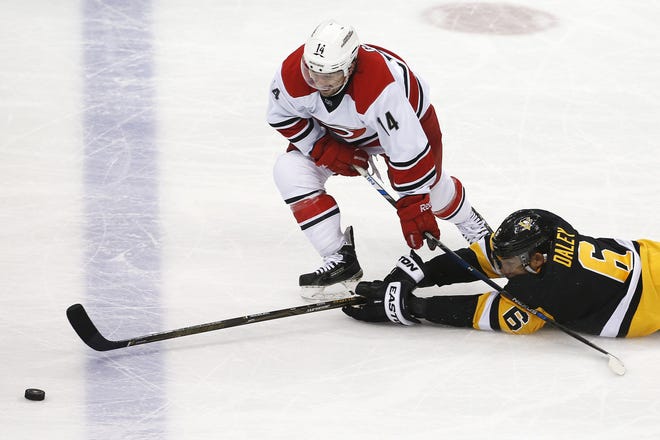 The Hurricanes' Nathan Gerbe (14) gets past a diving Penguins' Trevor Daley (6) on a breakaway during the first period of the Penguins' 4-2 win Thursday at Consol Energy Center.