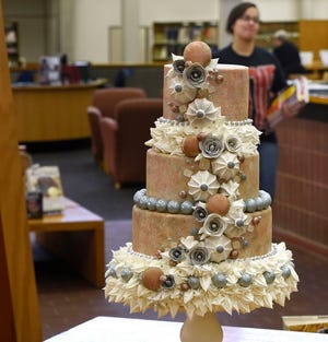 A lushly decorated, multi-tiered cake, created by BCC Baking Chef Kristine Hastreiter, is displayed in the Farley Library, in advance of the upcoming Cake Show.