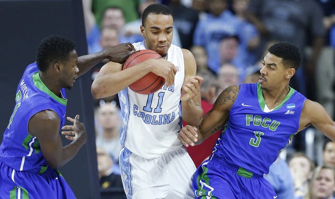 North Carolina forward Brice Johnson moves the ball as Florida Gulf Coast guard Julian DeBose, right and forward Demetris Morant defend during Thursday's first-round NCAA Tournament game in Raleigh. North Carolina won, 83-67. AP Photo/Gerry Broome